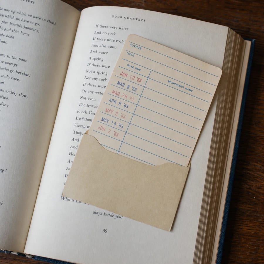 Ficha de biblioteca con sellos de préstamo